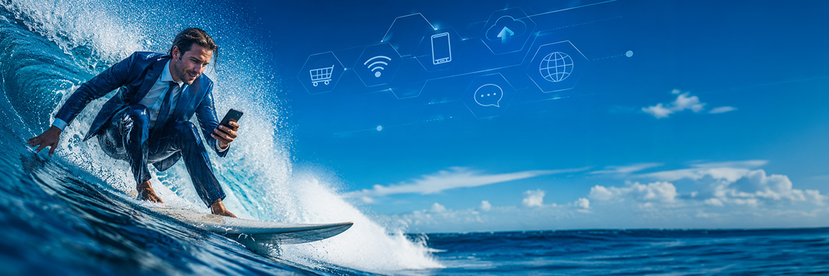 Un surfeur en costume sur une vague en train d'utiliser son smartphone.
