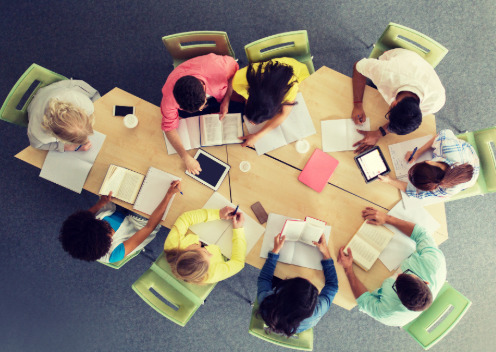 Des stagiaires, vus de dessus, collaborent autour d'une table à l'occasion d'une formation.